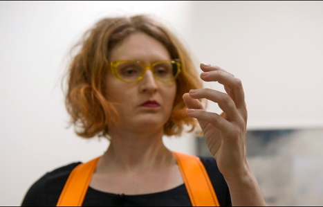 Headshot of EL Putnam looking at hand held in front of her, with fingers curled